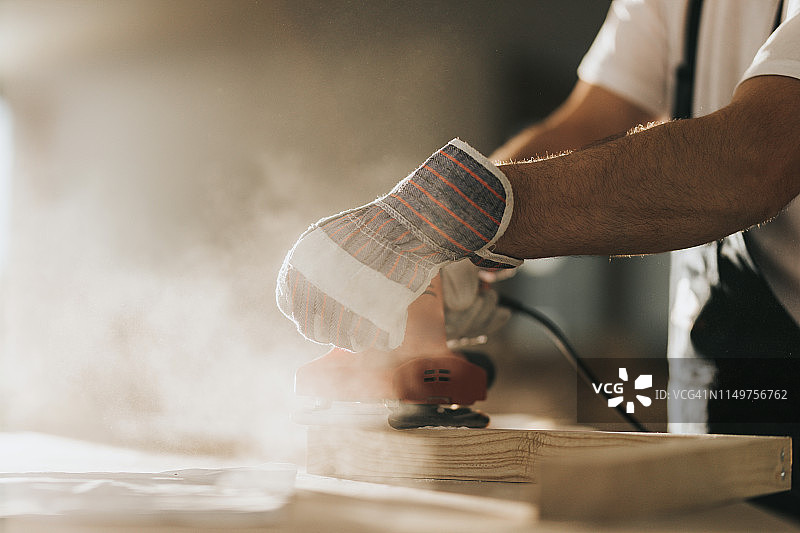 使用砂光机处理木板的手工工人图片素材