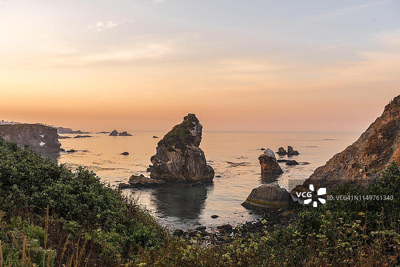 日出，崎岖的海岸景观，有许多岩石岛屿，哈里斯海滩州立公园，俄勒冈州，美国图片素材