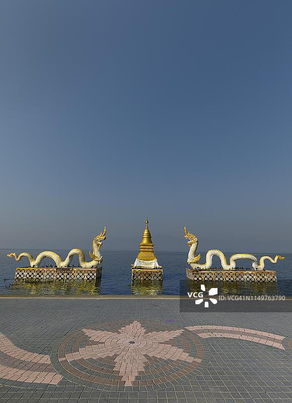 泰国帕尧湖畔的金色佛塔和白色那伽雕像图片素材
