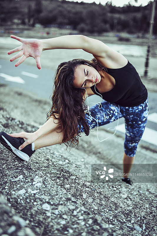 在台阶上伸展的性感女运动员图片素材