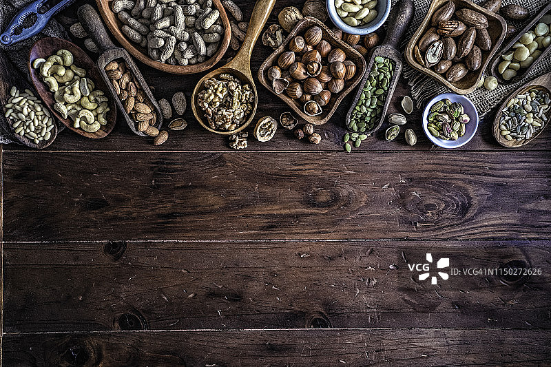 旧式乡村厨房桌子上各种干果和坚果，构成带复制空间的框架图片素材