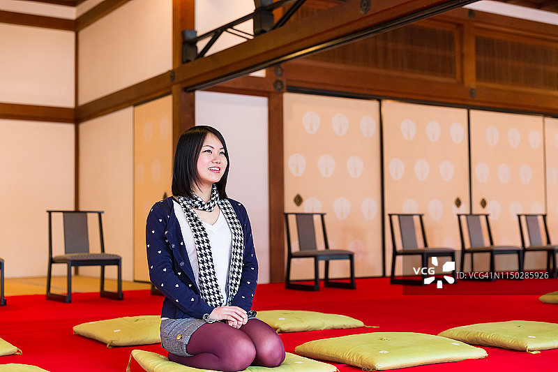 年轻女性在寺庙的日式石庭前冥想图片素材