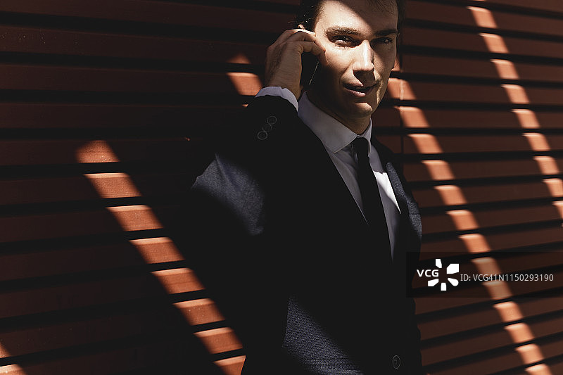 户外使用智能手机的年轻商人图片素材