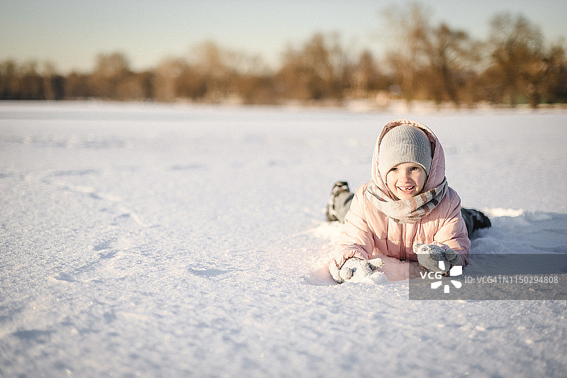 躺在雪地里的小女孩肖像照图片素材