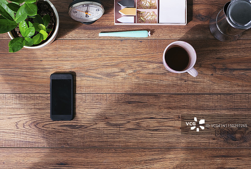 带智能手机和咖啡杯的木质办公桌俯视图图片素材