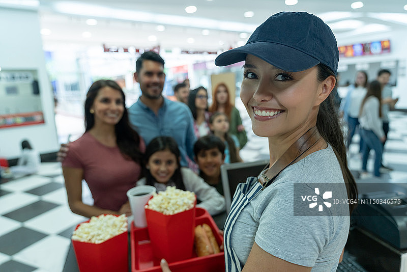 在电影院特许摊位卖食物的女人图片素材