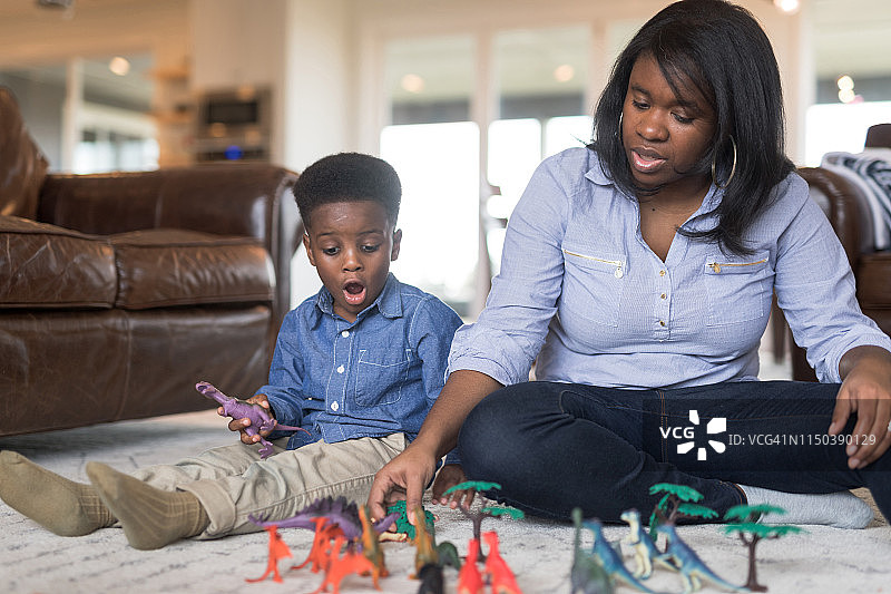 男孩和妈妈一起玩恐龙图片素材
