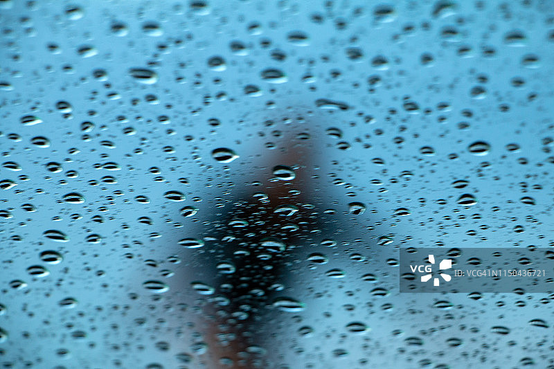 透过雨滴窗户看模糊的人影图片素材