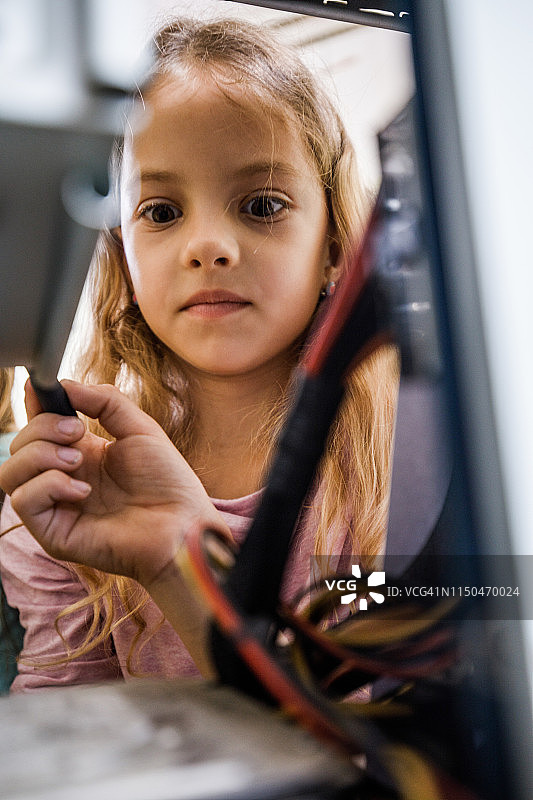 小女孩用螺丝刀修理电脑图片素材