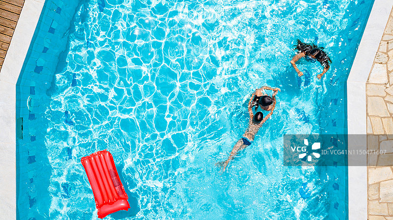 在游泳池里玩耍的三个孩子的俯视图图片素材