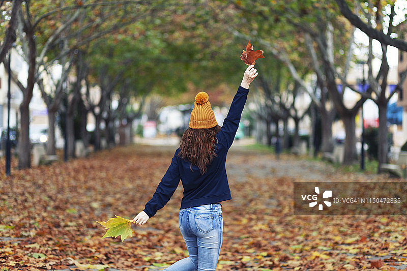 在秋叶上跳舞的45岁女人图片素材