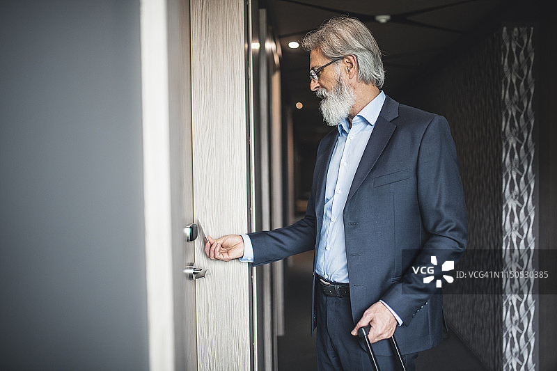 商人使用无钥匙门卡进入酒店房间图片素材