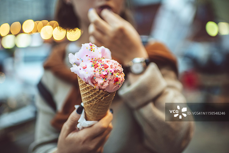 夏季户外，少女享用粉色冰淇淋图片素材