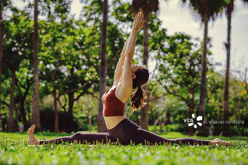 哈奴曼式瑜伽——在树木和自然中锻炼的亚洲女性图片素材