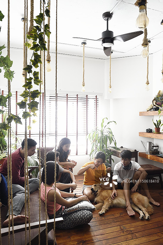 一群年轻人和一只狗在客厅里图片素材