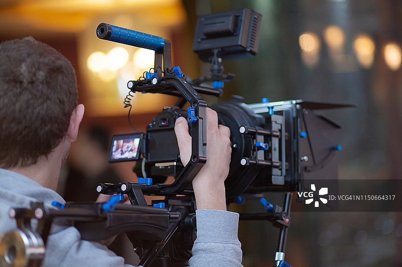 年轻男摄影师用相机拍摄视频或照片图片素材