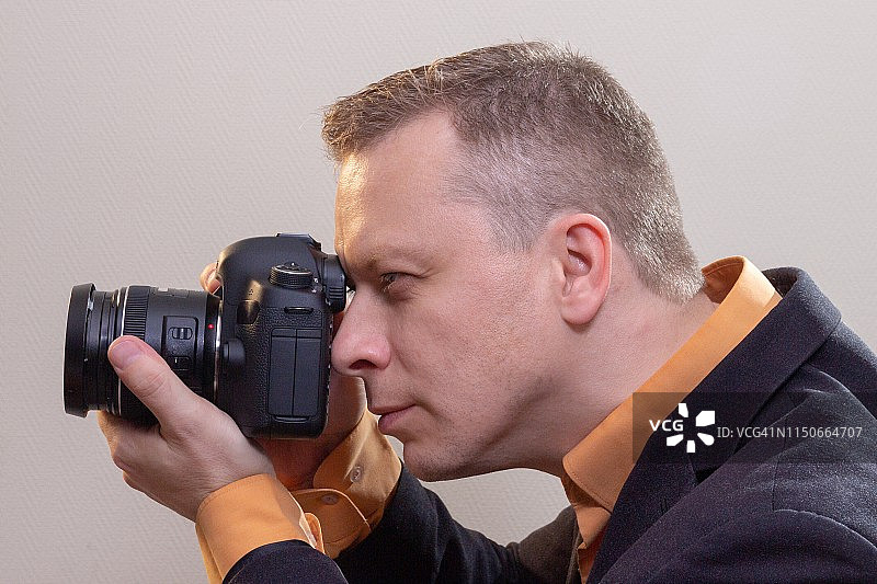 年轻男摄影师用相机拍摄视频或照片图片素材