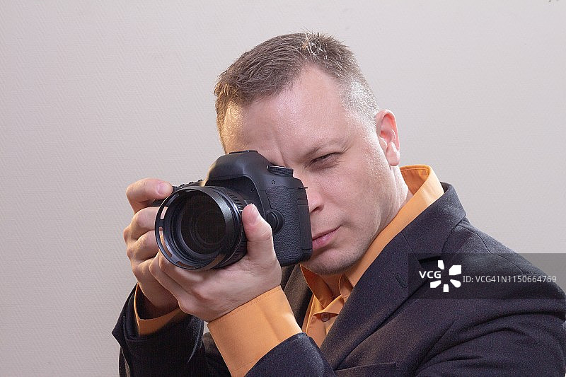 年轻男摄影师用相机拍摄视频或照片图片素材
