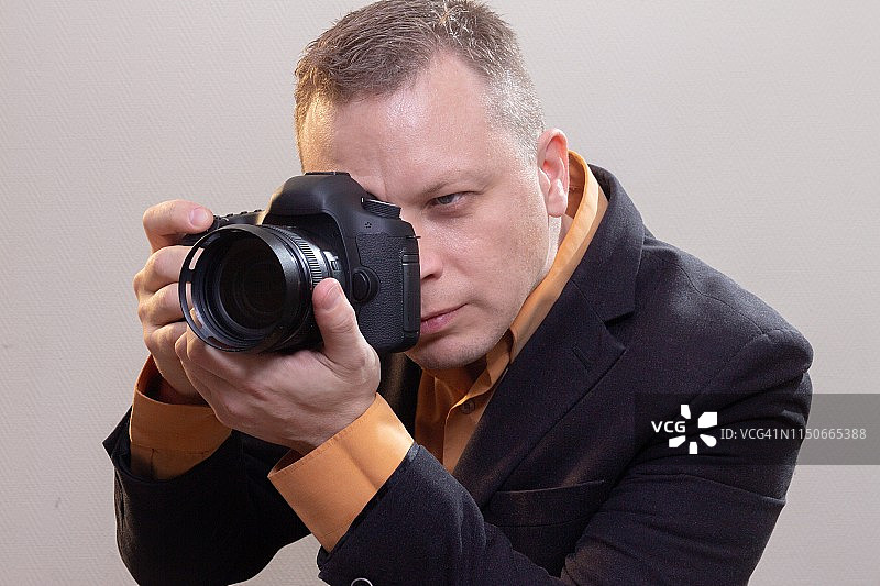 年轻男摄影师用相机拍摄视频或照片图片素材