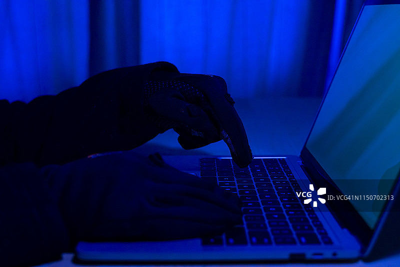 夜晚在笔记本电脑上打字的神秘之手图片素材