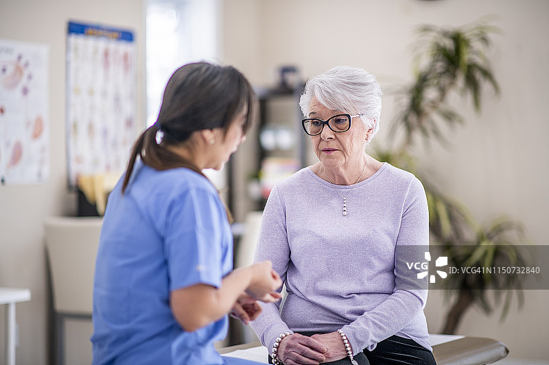 在医生办公室里悲伤的老年妇女图片素材