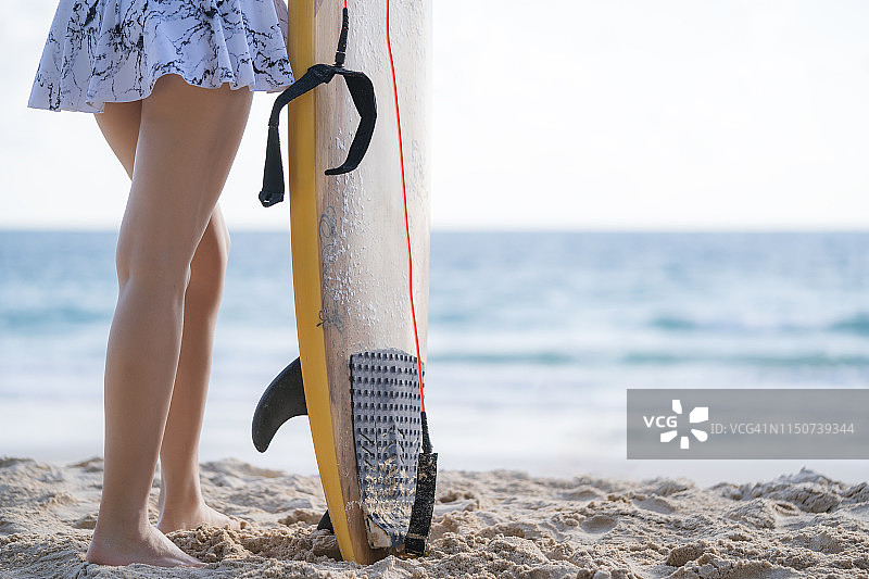 在海滩上拿着冲浪板的女人图片素材