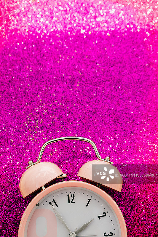 粉色闪光背景中的粉色闹钟图片素材