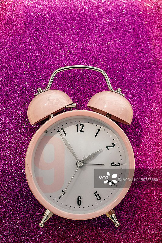 粉色闪光背景中的粉色闹钟图片素材