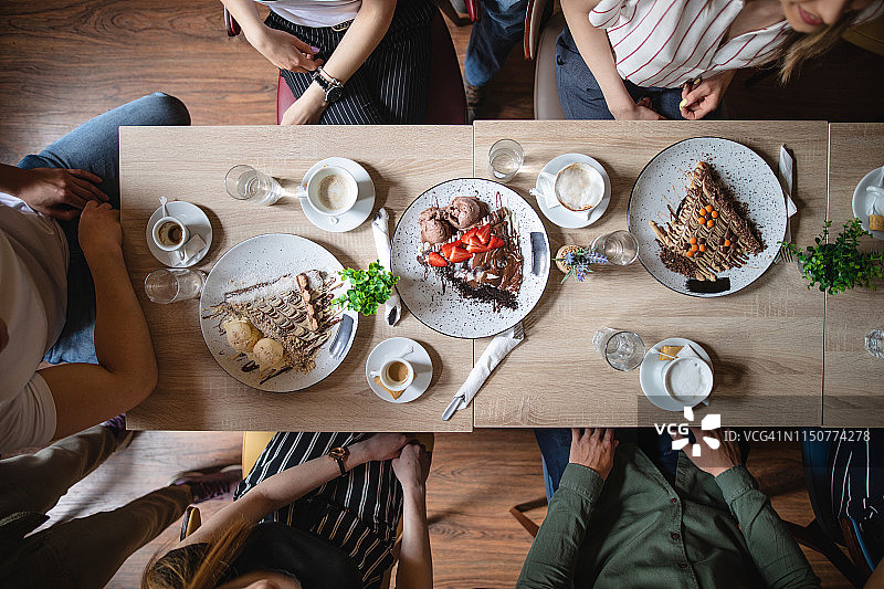 一群穿着讲究的朋友在当地煎饼店吃煎饼图片素材