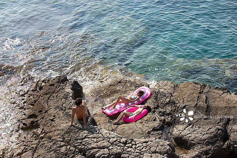 一家人在多石的海滩上放松图片素材