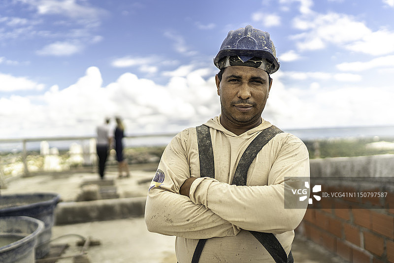 建筑工地上交叉双臂站立的工人图片素材