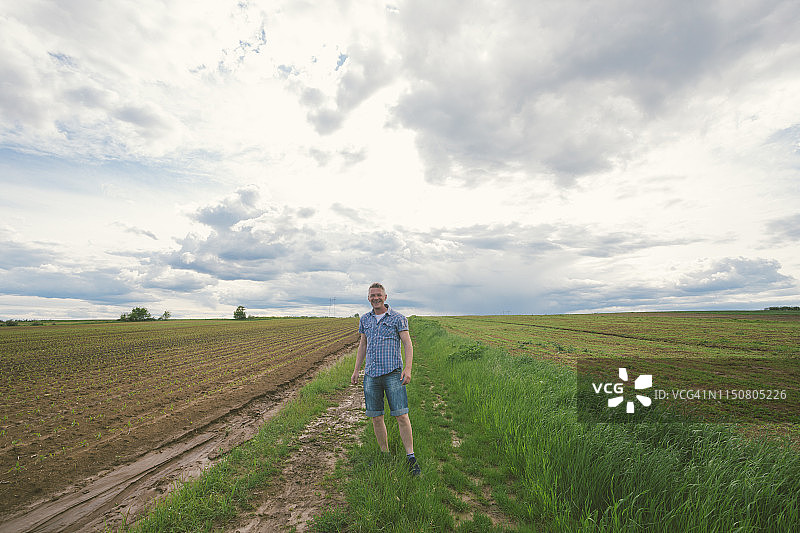 成年农民在春天暴雨后的玉米泥泞农田图片素材