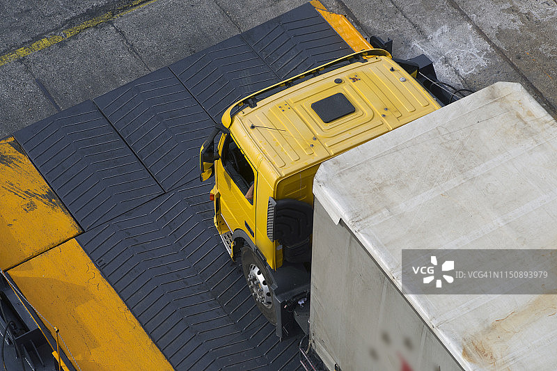 在希腊比雷埃夫斯港口，大型半挂卡车驶上汽车渡轮入口坡道图片素材