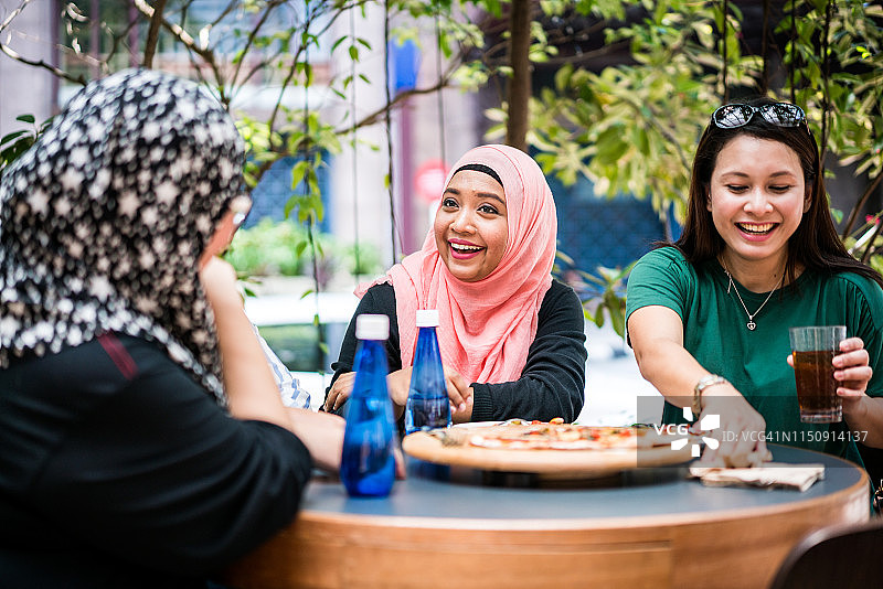 马来西亚女人一起吃披萨图片素材
