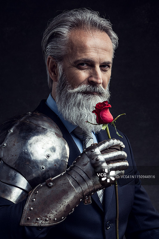 手持红玫瑰的优雅老年商人图片素材