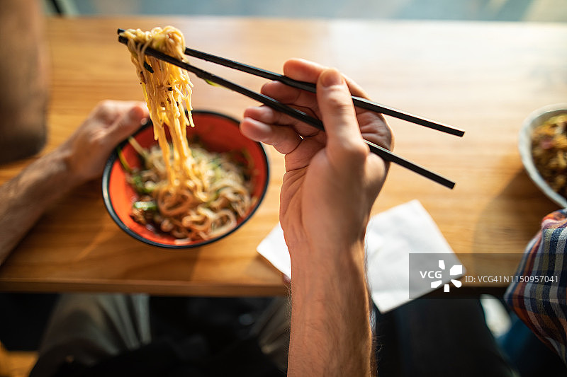 男子正在吃蔬菜面条图片素材