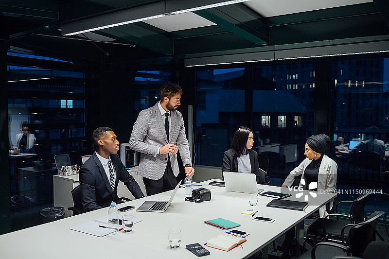 女商人和男士在会议桌上讨论图片素材