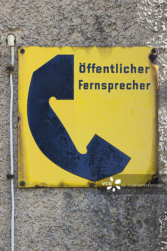 信息标志:德国联邦邮局20世纪50年代的公用电话亭,位于德国巴伐利亚州房屋墙壁上图片素材