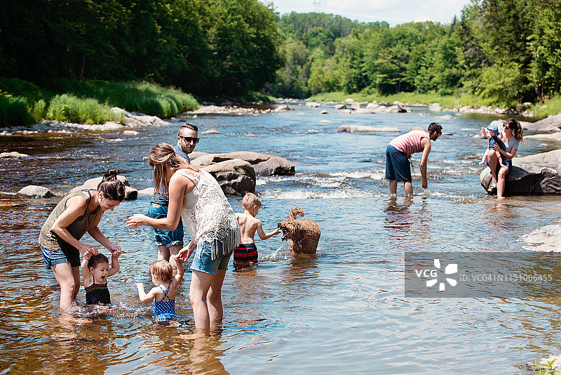 千禧一代家庭在河边玩耍图片素材