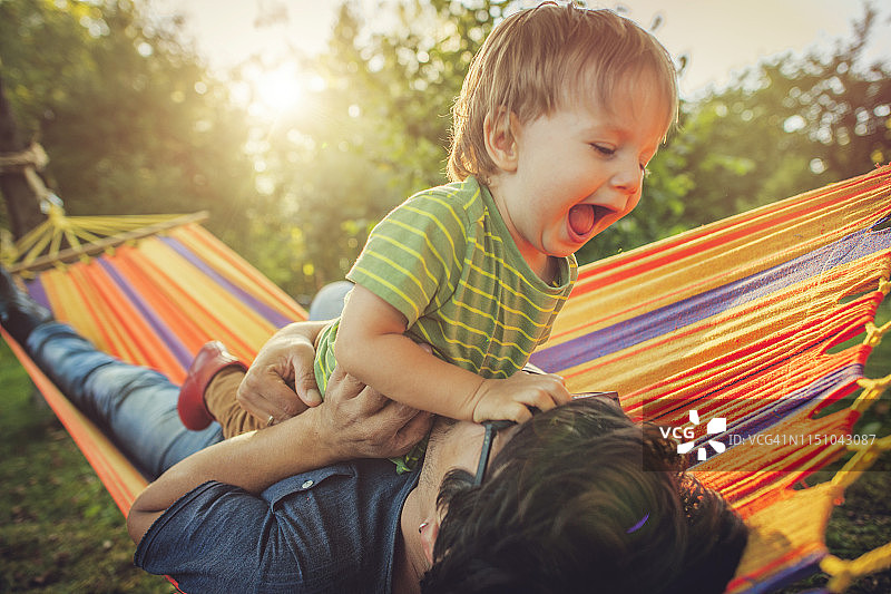 父子在吊床上享受春夏时光图片素材