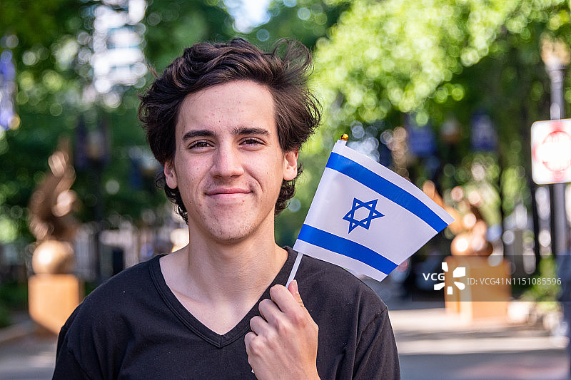 挥舞以色列国旗的微笑年轻人图片素材