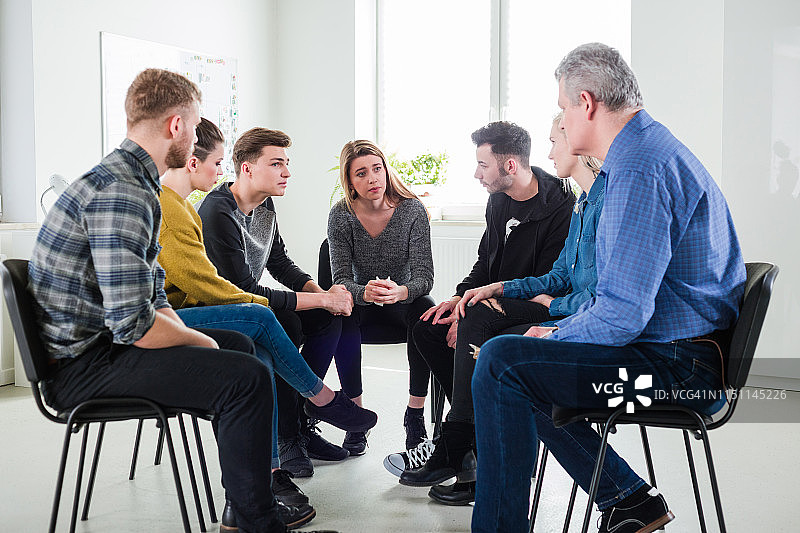 男治疗师帮助沮丧的年轻学生图片素材