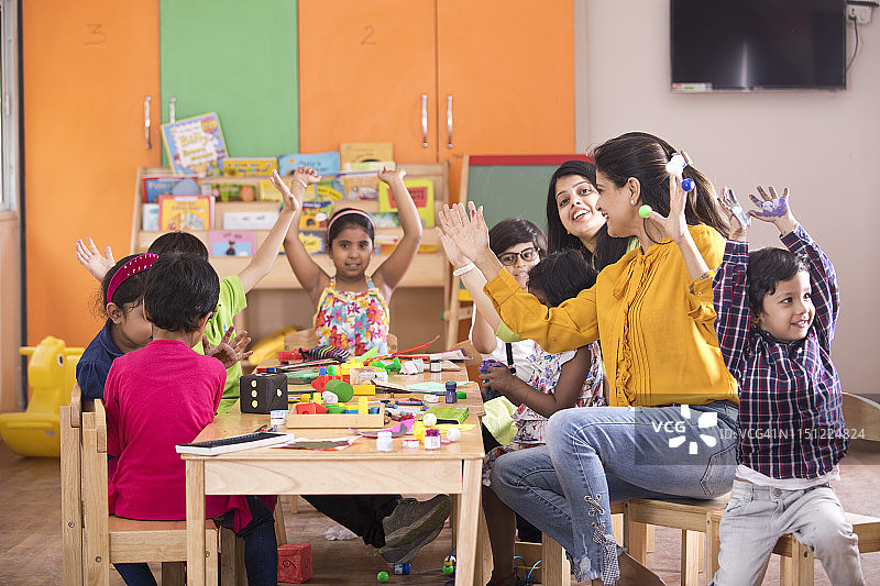 老师和学龄前儿童在课堂上进行手指画图片素材