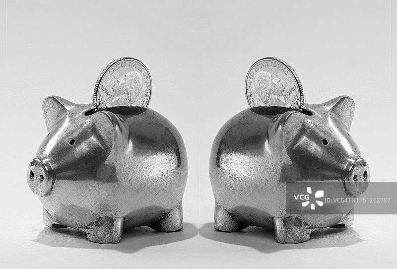 两个装有美国25美分硬币的金属小猪储蓄罐图片素材