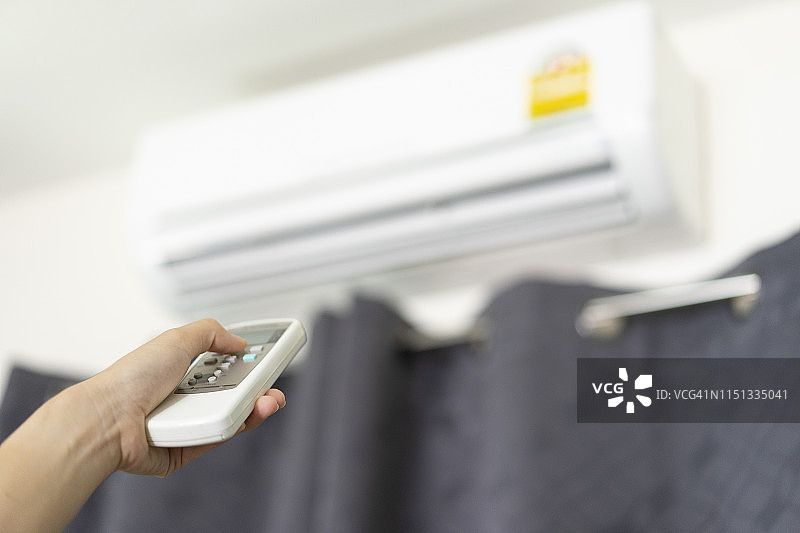 用遥控器打开空调的手图片素材
