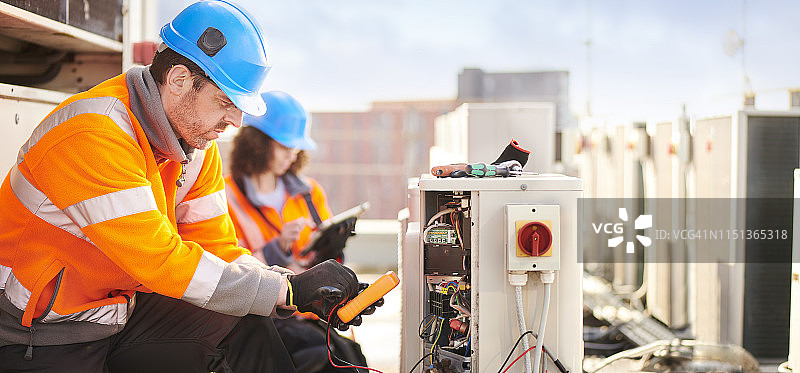 屋顶上的空调维修团队图片素材