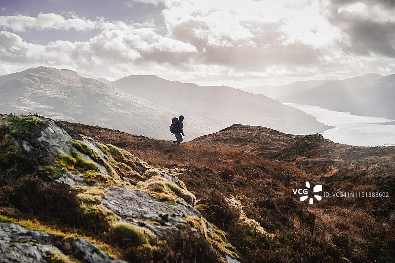 女性背包客在苏格兰阿罗char下山走向湖边图片素材