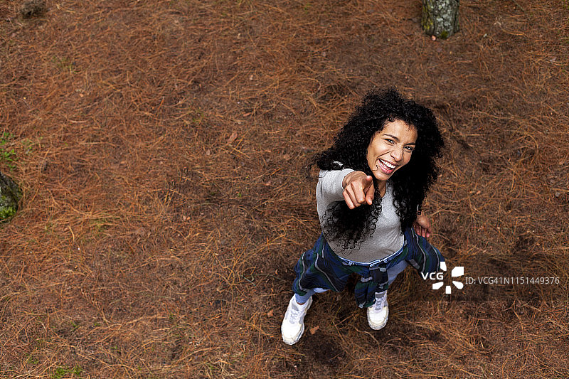 森林中欣赏自然的黑发非洲裔女人，指向镜头图片素材