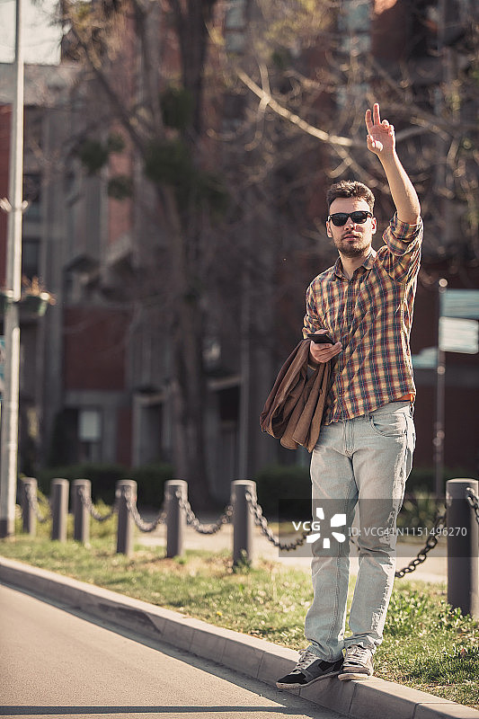 年轻男人在街上叫出租车图片素材