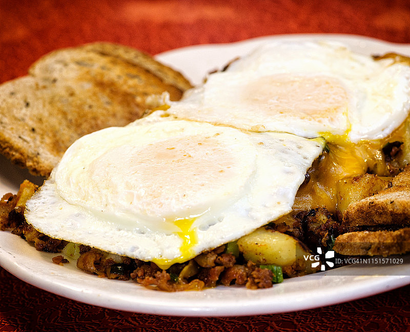 巴比伦餐厅的丰盛早餐：鸡蛋、吐司、土豆和薯饼图片素材